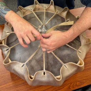 Lacing a hand drum frame in a community workshop